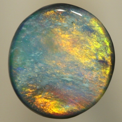 SOLID BLACK OPAL Golden fire of red and copper over a green - blue background